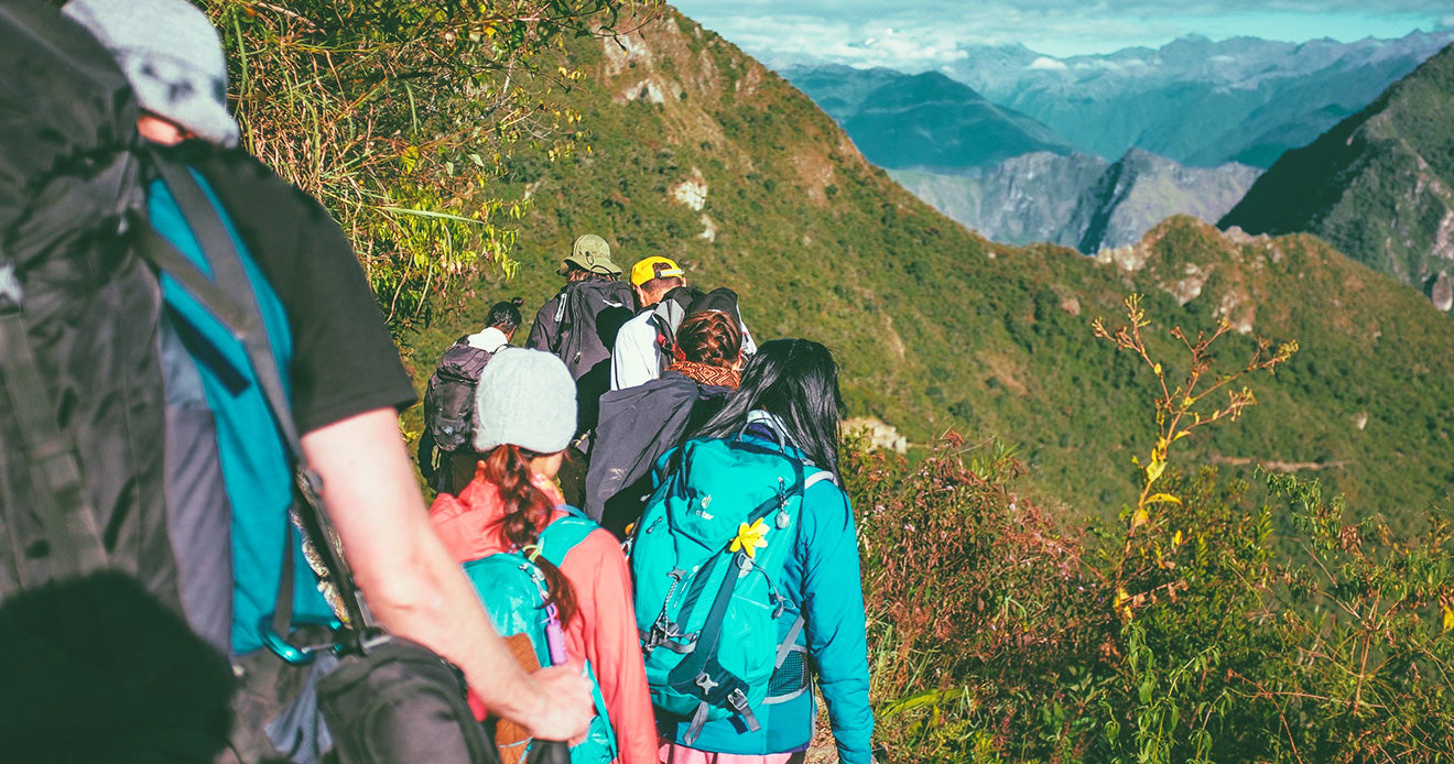 Hikers walking through a mountain pass with backpacks