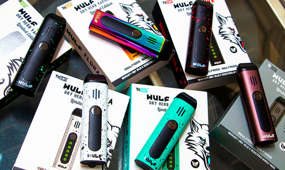 WULF vaporizers and their retail boxes arranged on a dark surface