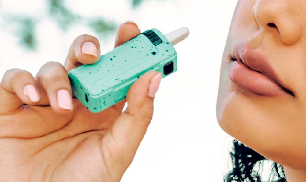 Hands holding a teal WULF Uni S 510 thread battery