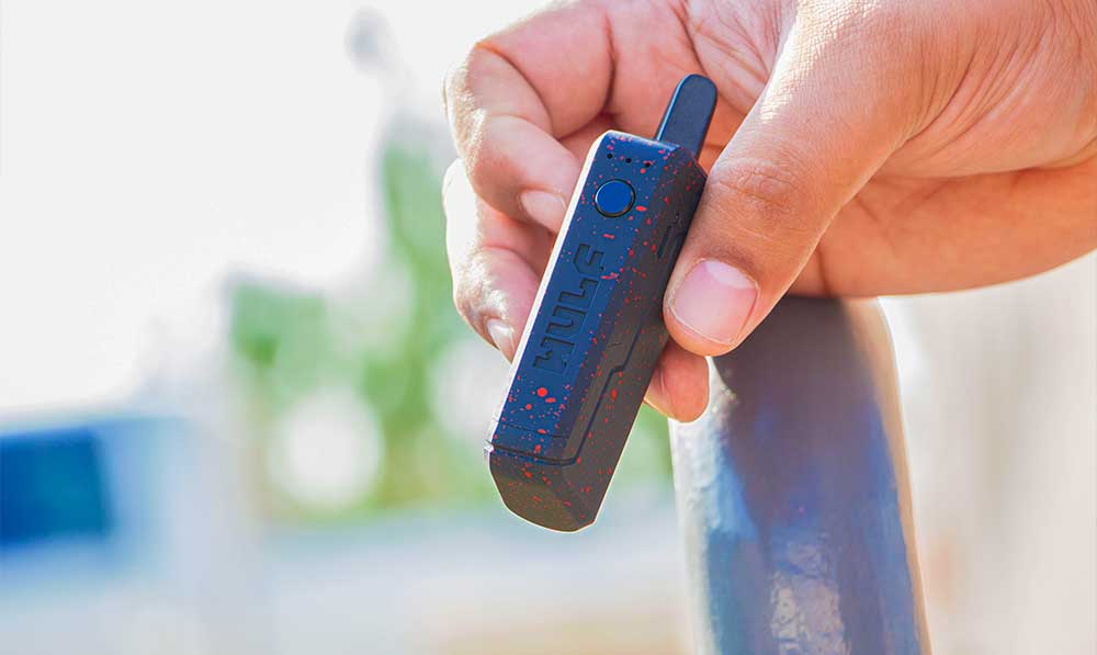 Hand holding a blue WULF Uni 510 thread battery