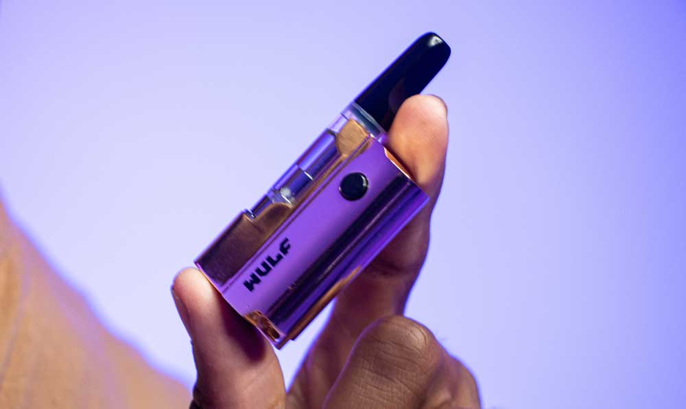 Hand holding a purple WULF Micro Plus 510 thread battery