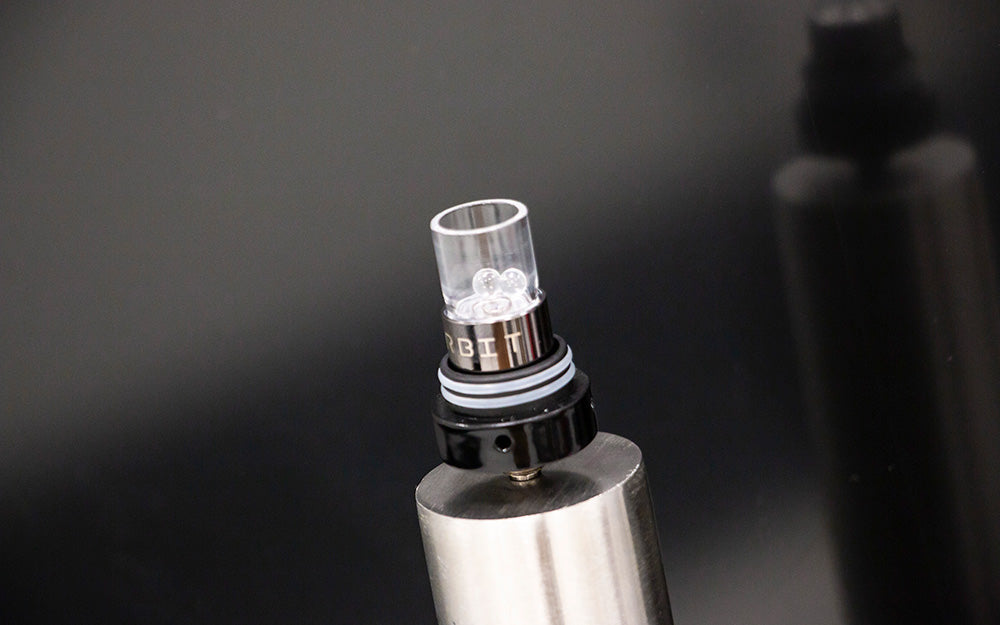 Close up of the WULF Orbit concentrate vaporizer atomizer and glass attachment