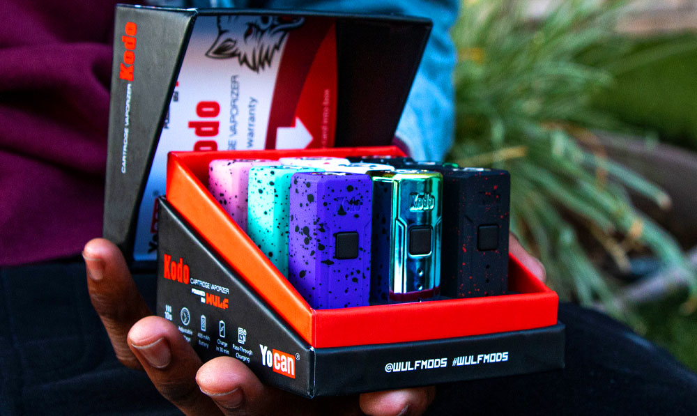 Man holding Wulf Mods KODO 9pk open in front of a planter