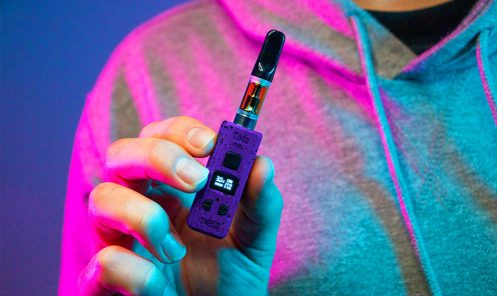 Man holding Wulf Mods KODO Pro under soft purple and blue studio lighting