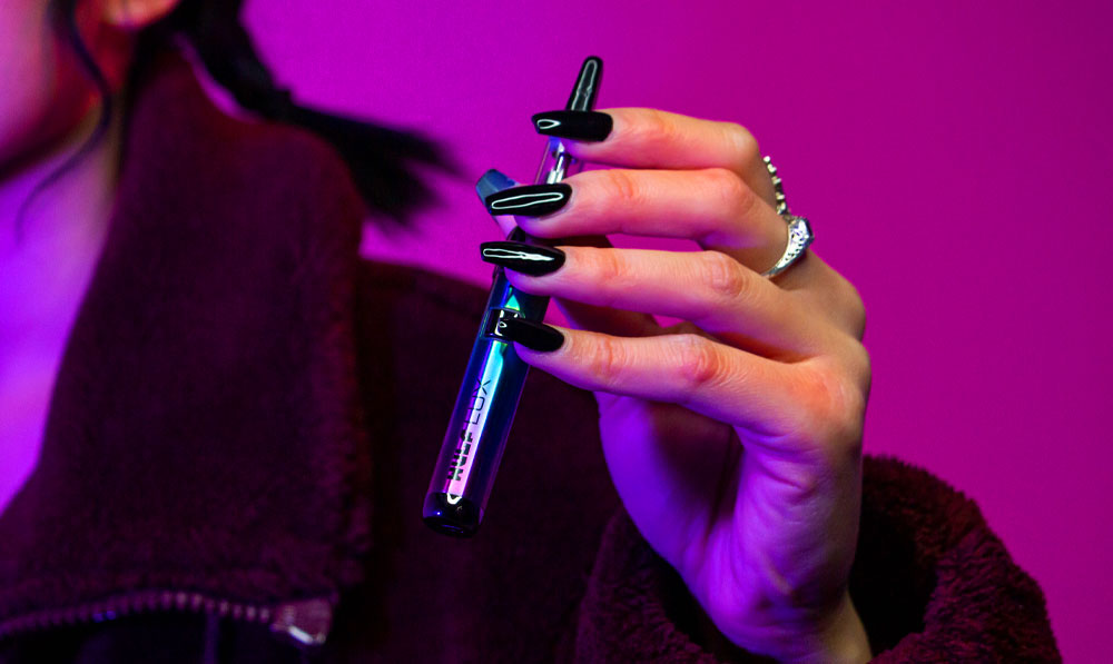 Woman holding Wulf Lux in front of pink studio background