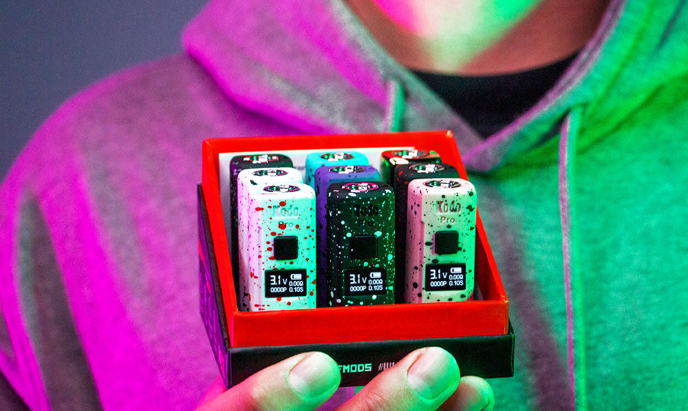 Man holding Wulf Kodo Pro in front of dark studio background with pink and green lighting