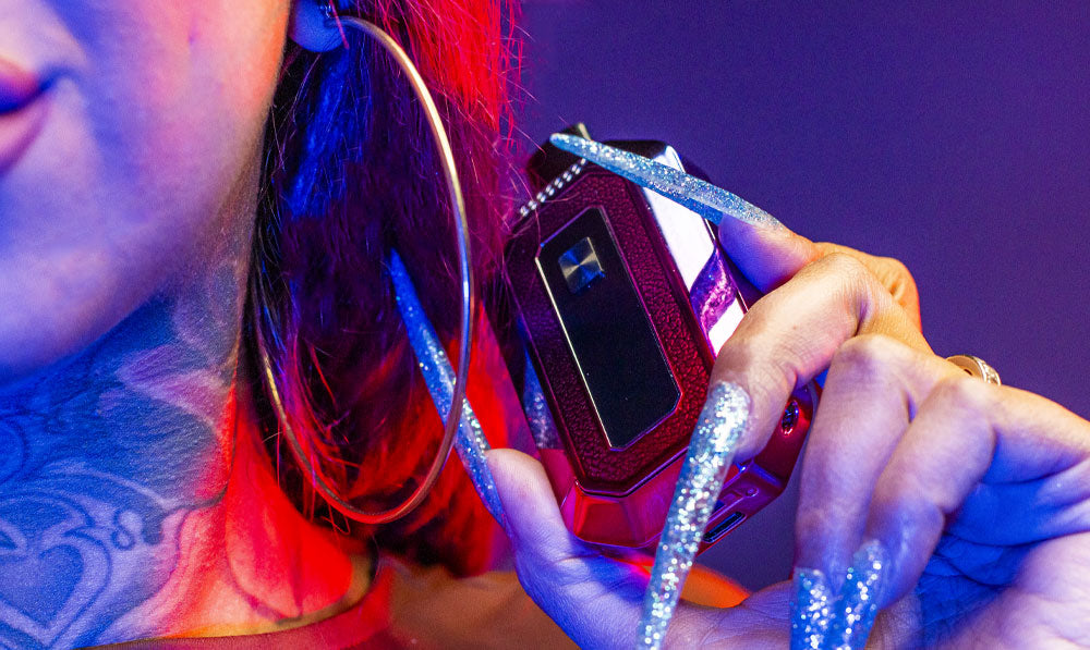 Woman holding Wulf Recon 4G in hand in front of purple studio background