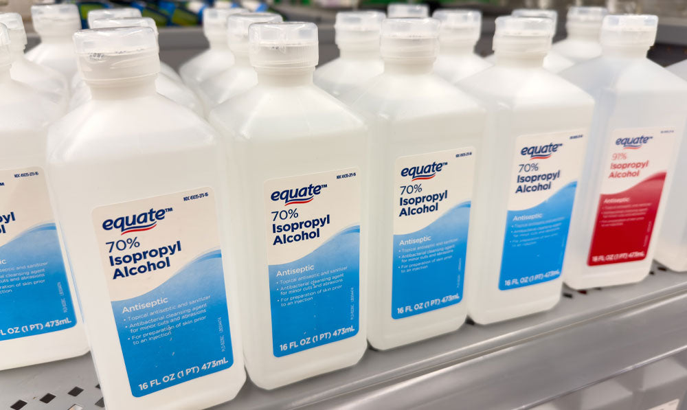 Shelf of several bottles of isopropyl alcohol standing together