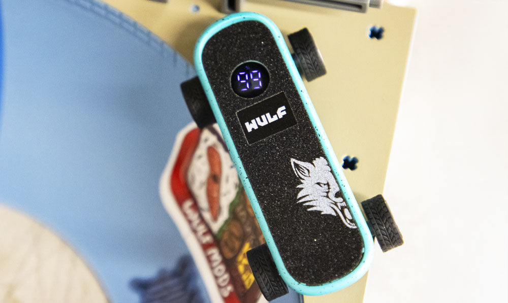 Close up of the WULF Deck skateboard shaped battery on top of a skatepark ramp