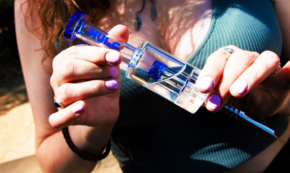 Woman holding Blue Wulf Mods Nova Nectar Collector on a park trail