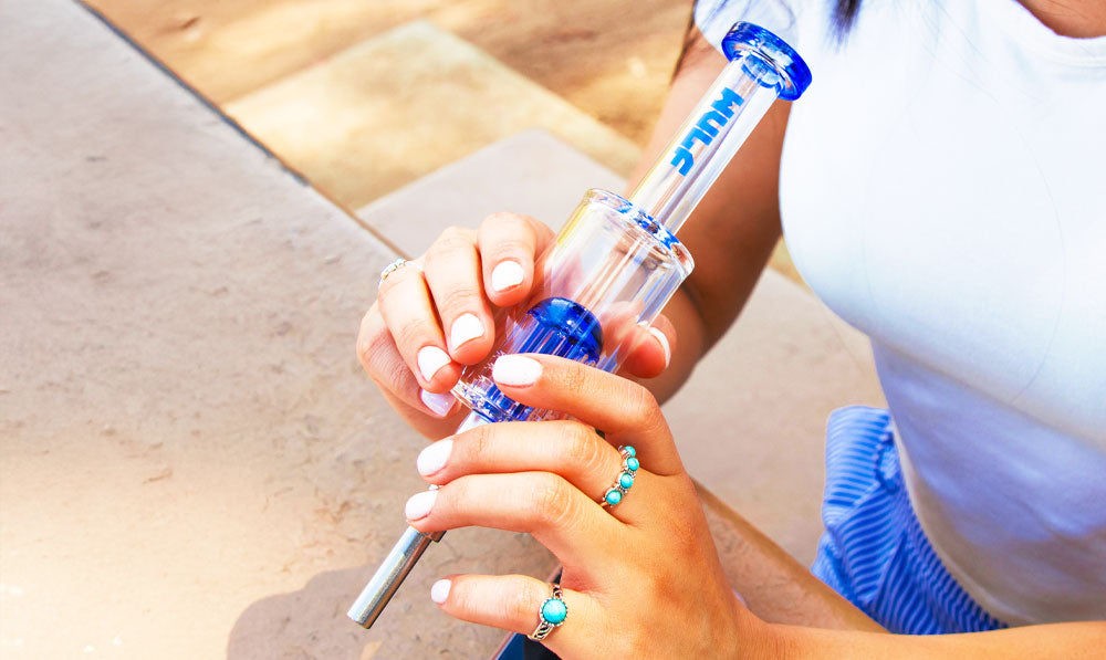 Woman holding Blue Wulf Mods Timber Nectar Collector at a park table