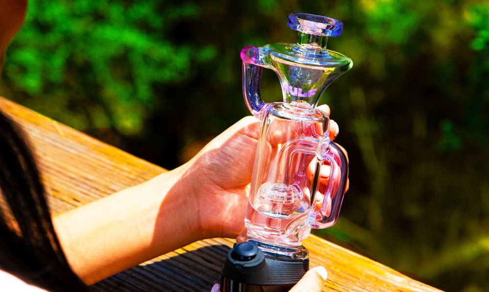 Person holding a WULF Quake glass attachment on a wooden surface