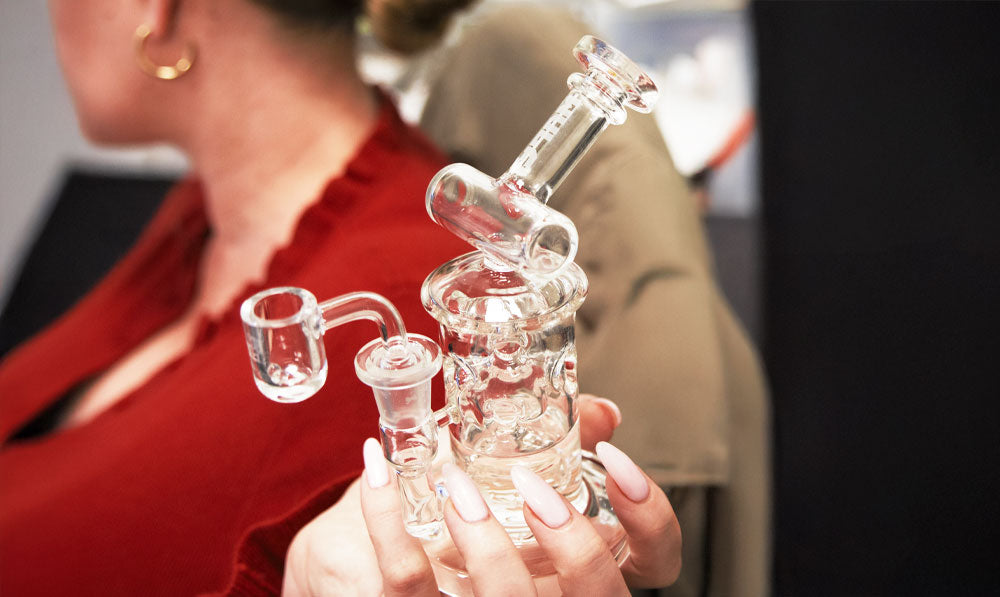 Person holding a WULF Tyde dab rig in an office
