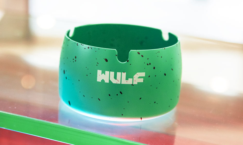 Teal WULF Cache ashtray on a reflective glass surface