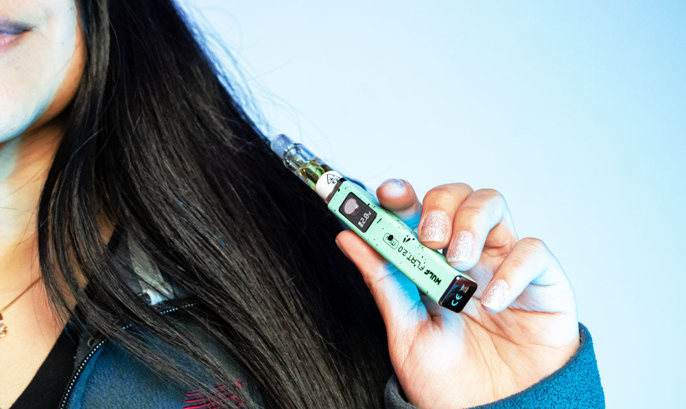 Woman holding Wulf Flat Mini 2 in front of teal studio background