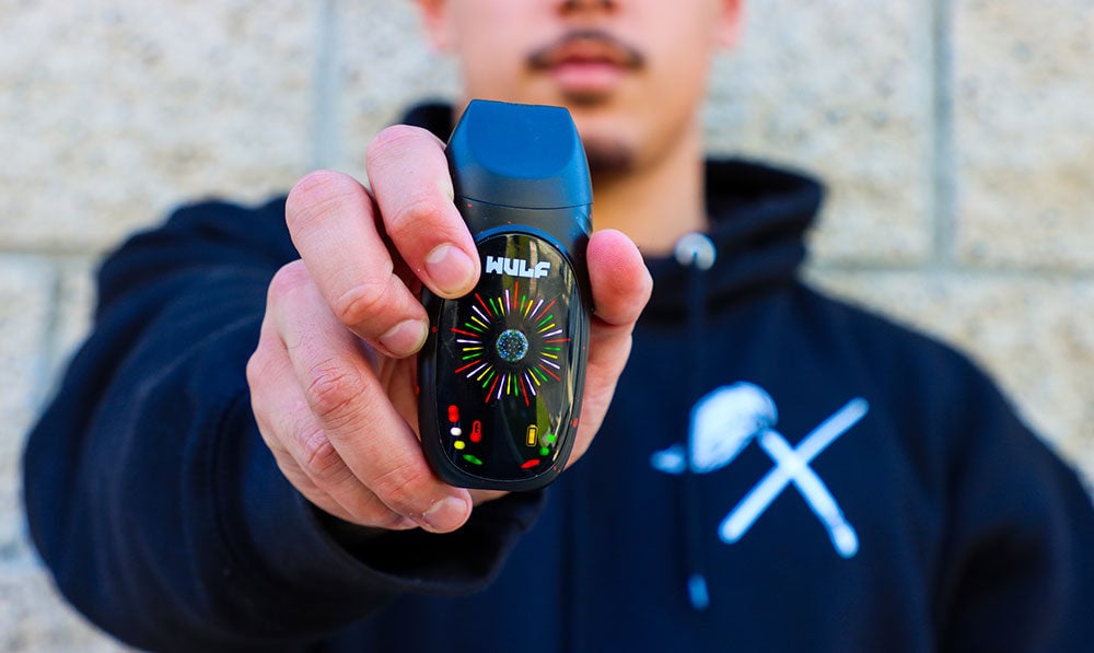 man showing off the Wulf Faze Dry Herb Vaporizer outside office building