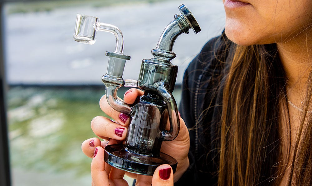 hands holding Wulf glassware dab rig on lifestyle background