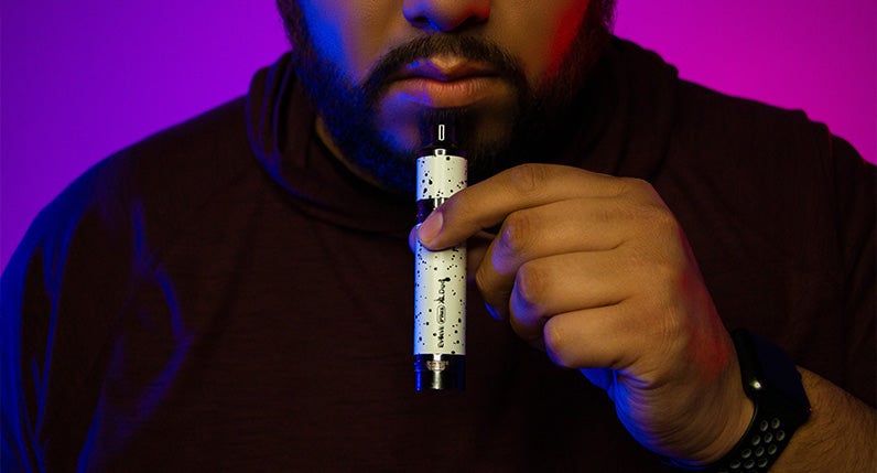 Man holding Wulf Evolve Plus XL Duo in front of purple studio background