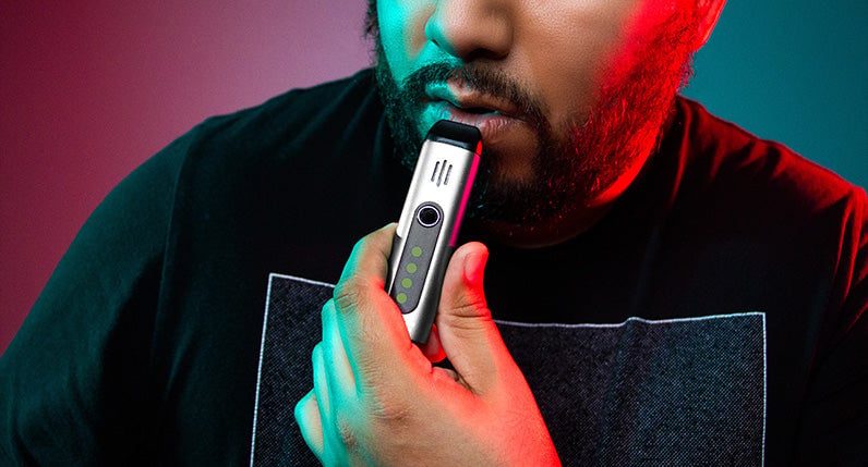 Person in a black shirt holding a WULF Flora portable dry herb vaporizer