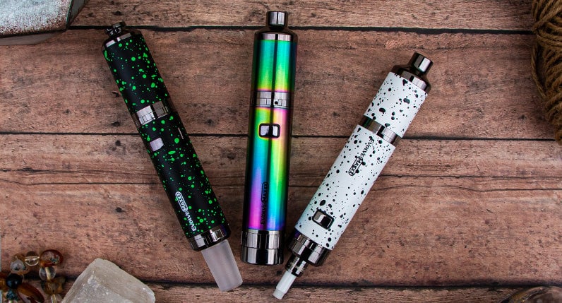 WULF Evolve Maxxx three in one vaporizers in several finishes standing on weathered wood