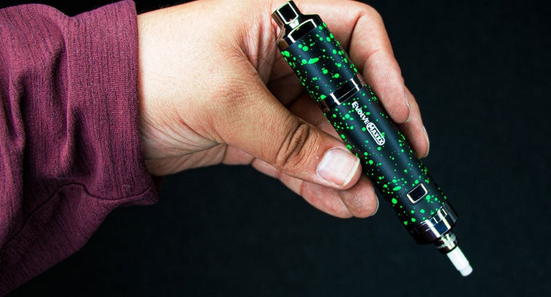 Hand holding a WULF Evolve Maxxx in black with green spatter