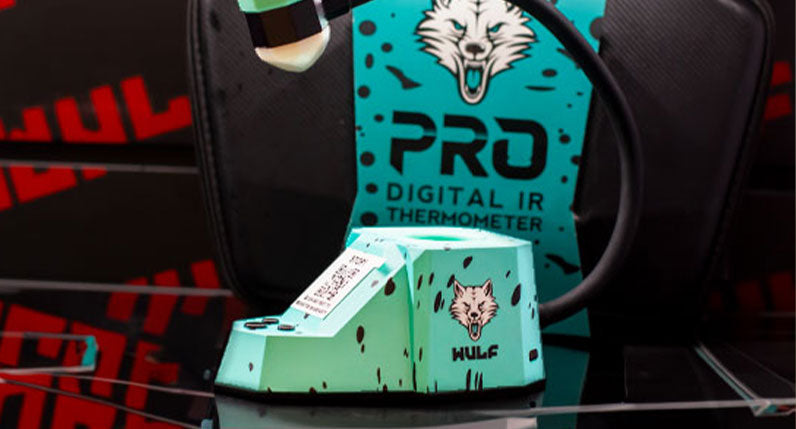 Close up of Teal Black Spatter Wulf Dab Rite Pro on table with packaging
