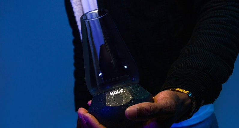 man in black jacket holding the Wulf Fang with blue background
