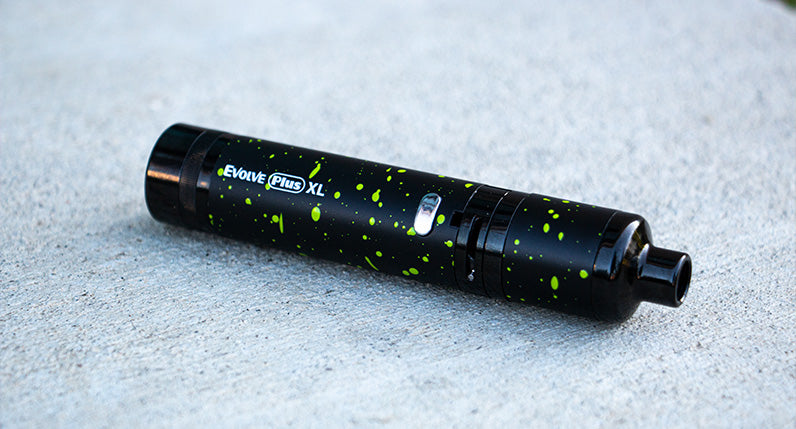 WULF Evolve Plus XL concentrate vaporizer in black with green spatter on a pale surface
